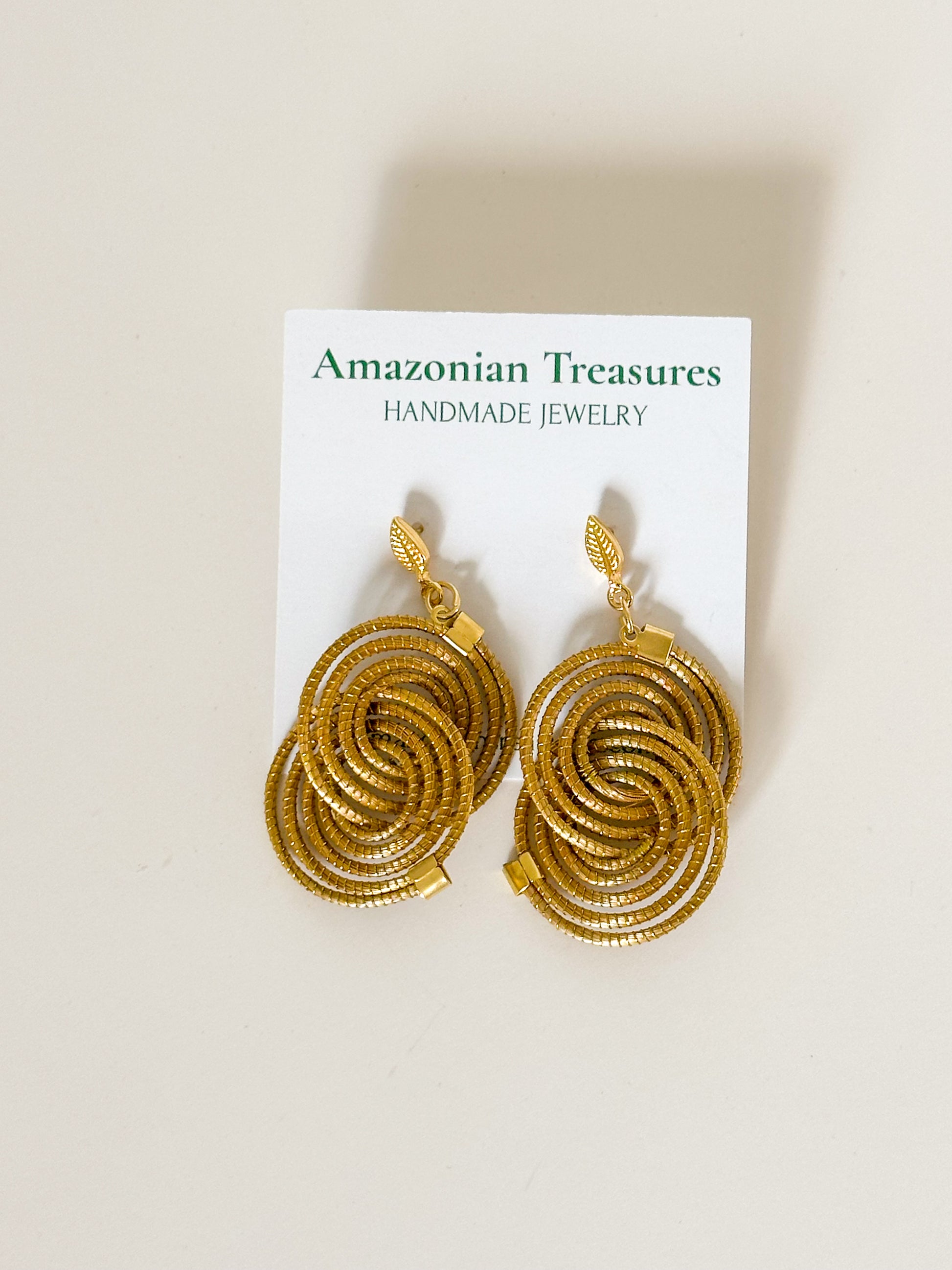 Golden grass spiral earrings from the Espiral Dourada Set handcrafted with capim dourado by Brazilian artisans.