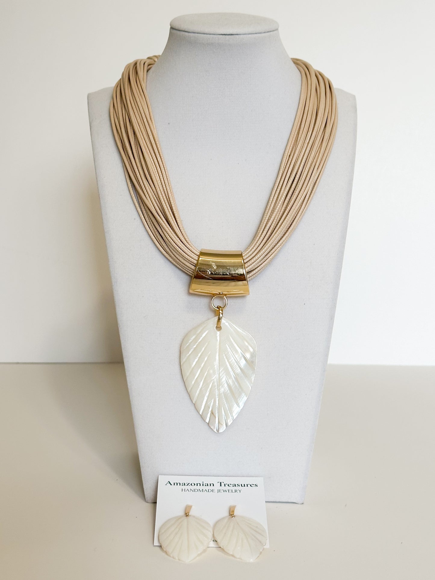 Handmade mother of pearl leaf necklace and earrings set crafted by an Amazon artisan.