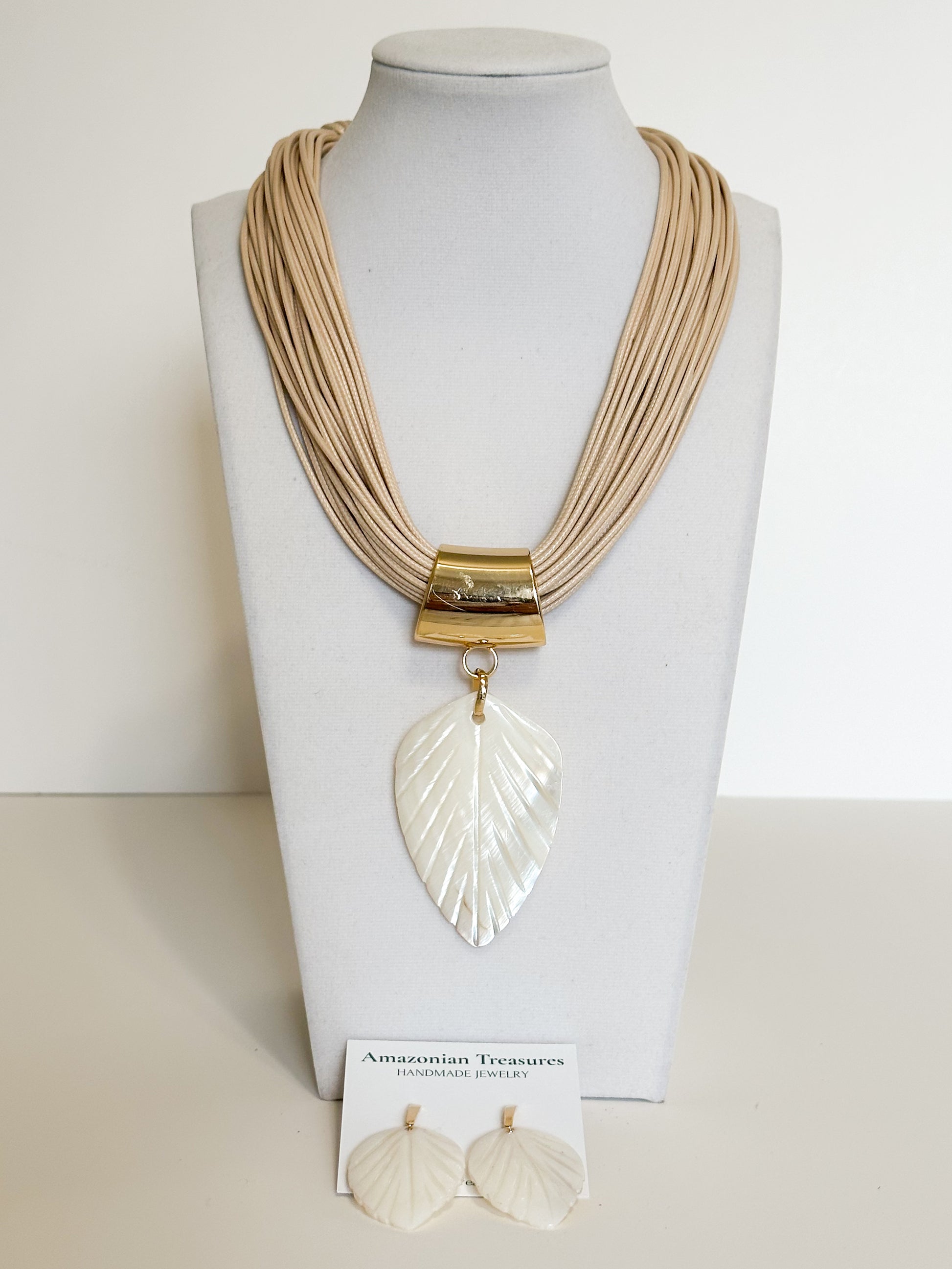 Handmade mother of pearl leaf necklace and earrings set crafted by an Amazon artisan.