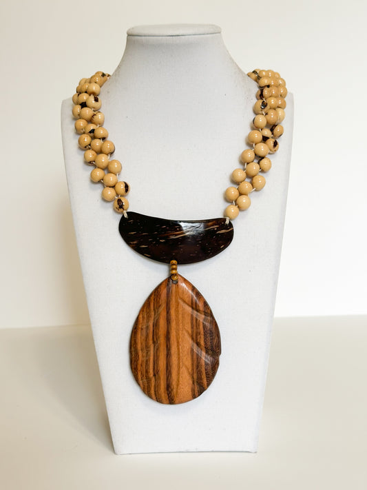 Handmade necklace crafted with açaí seeds, cuia gourd and muiracatiara wood by Brazilian artisan.