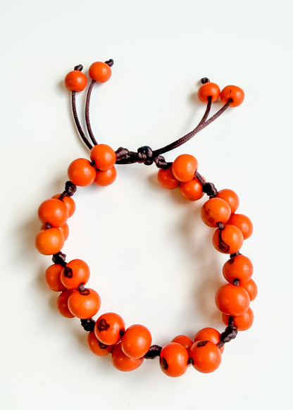 Handmade orange bracelet made with natural Açaí seeds from Brazil