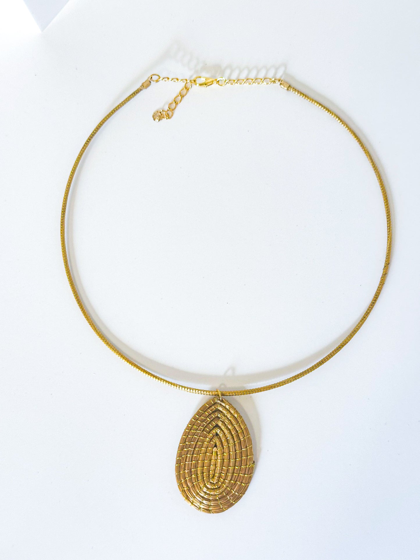 Handwoven golden grass necklace with leaf pendant made from capim dourado.
