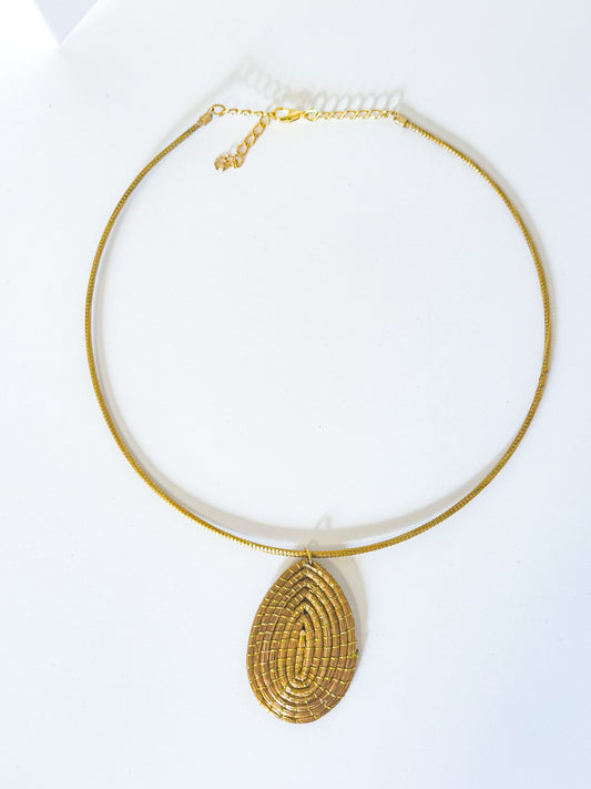 Handwoven golden grass necklace with leaf pendant made from capim dourado.