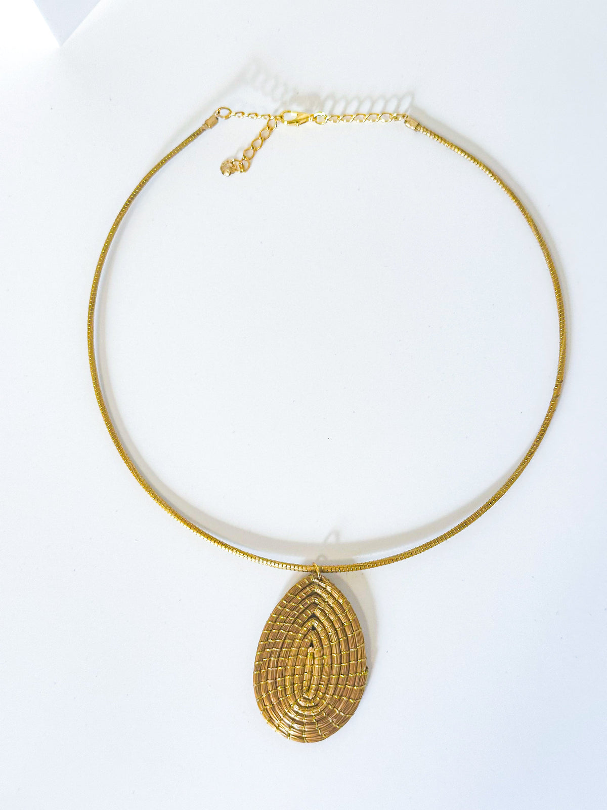 Handwoven golden grass necklace with leaf pendant made from capim dourado.