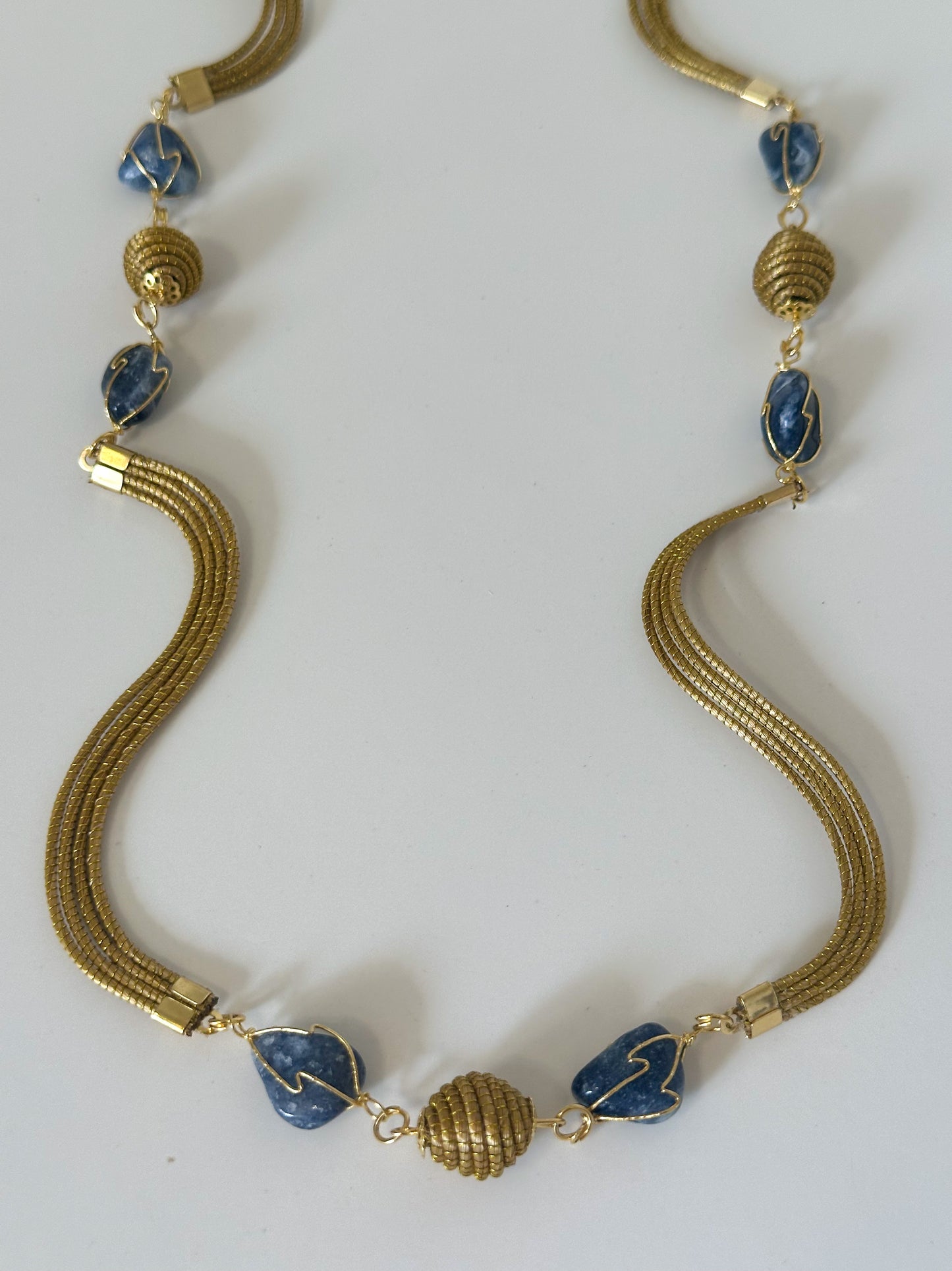 Handwoven golden grass necklace with soldalite gemstone detail