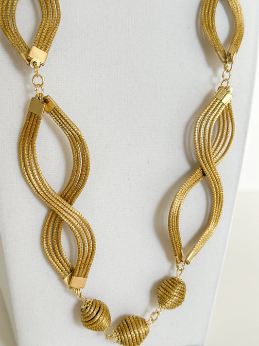 Laços Dourados golden grass infinity necklace set featuring handwoven double-loop design with matching golden grass earrings. closeup