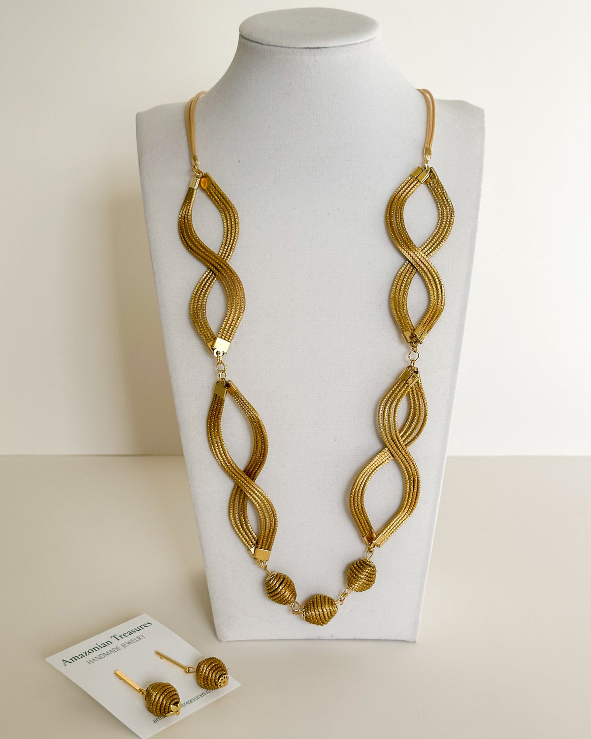 Laços Dourados golden grass infinity necklace set featuring handwoven double-loop design with matching golden grass earrings.