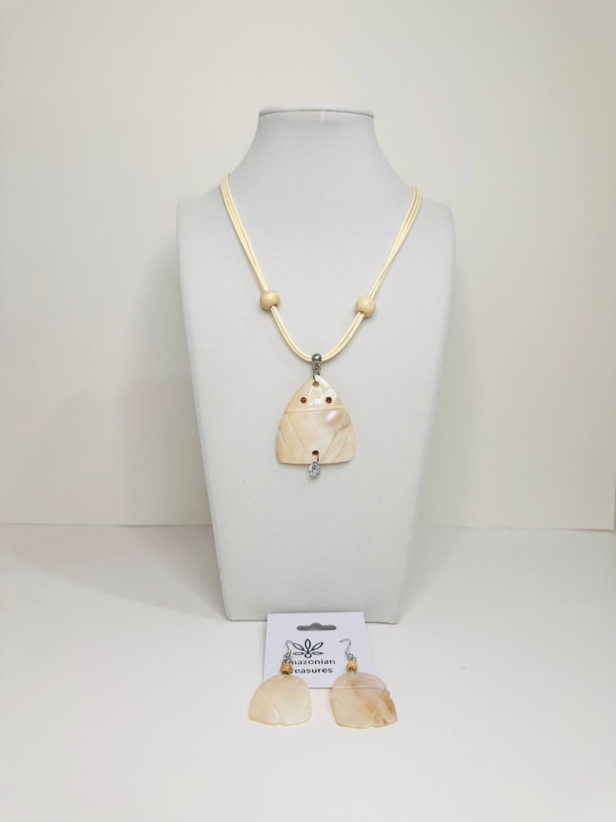 Mother of pearl Muiraquitã necklace and earring set displayed on white bust