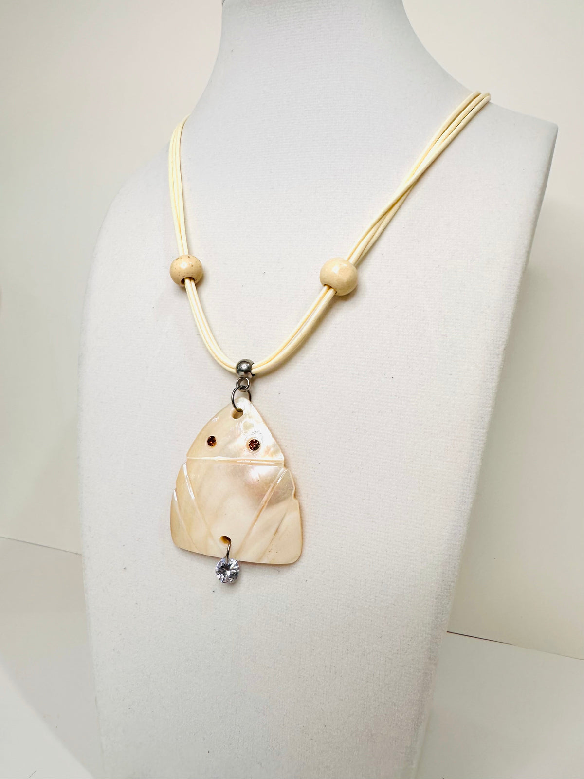 Carved mother of pearl Muirakitã pendant with soft iridescent glow