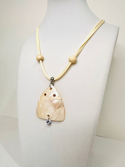 Carved mother of pearl Muirakitã pendant with soft iridescent glow