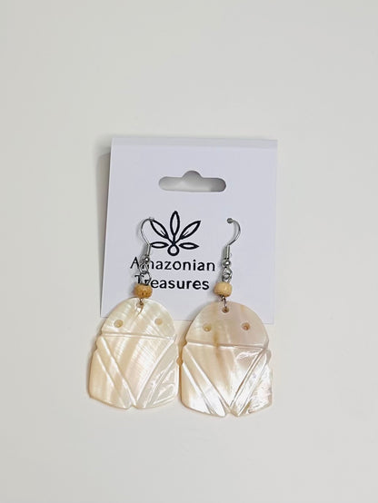 Pair of Muiraquita earrings made of mother of pearl on a 'Amazonian Treasures' branded card