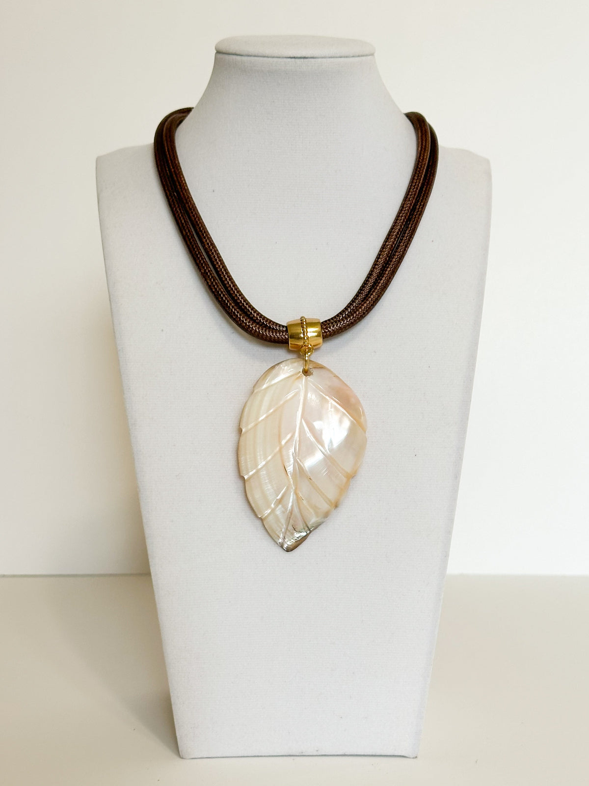 Natural mother of pearl leaf pendant necklace with layered rope cord.