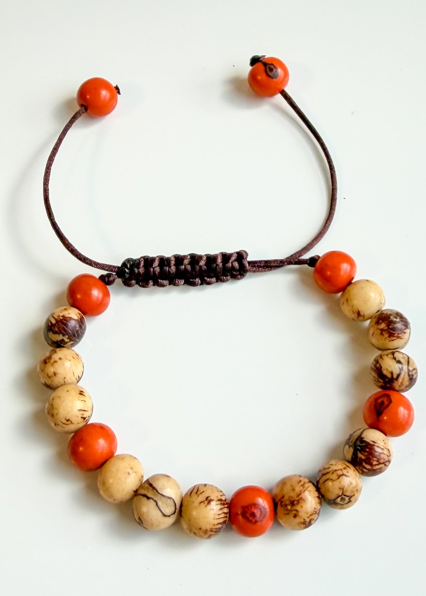 Nature-crafted Amazon seed bracelet orange detail