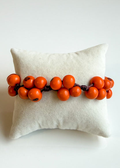 Orange Açaí seed bracelet handcrafted by an independent Brazilian artisan