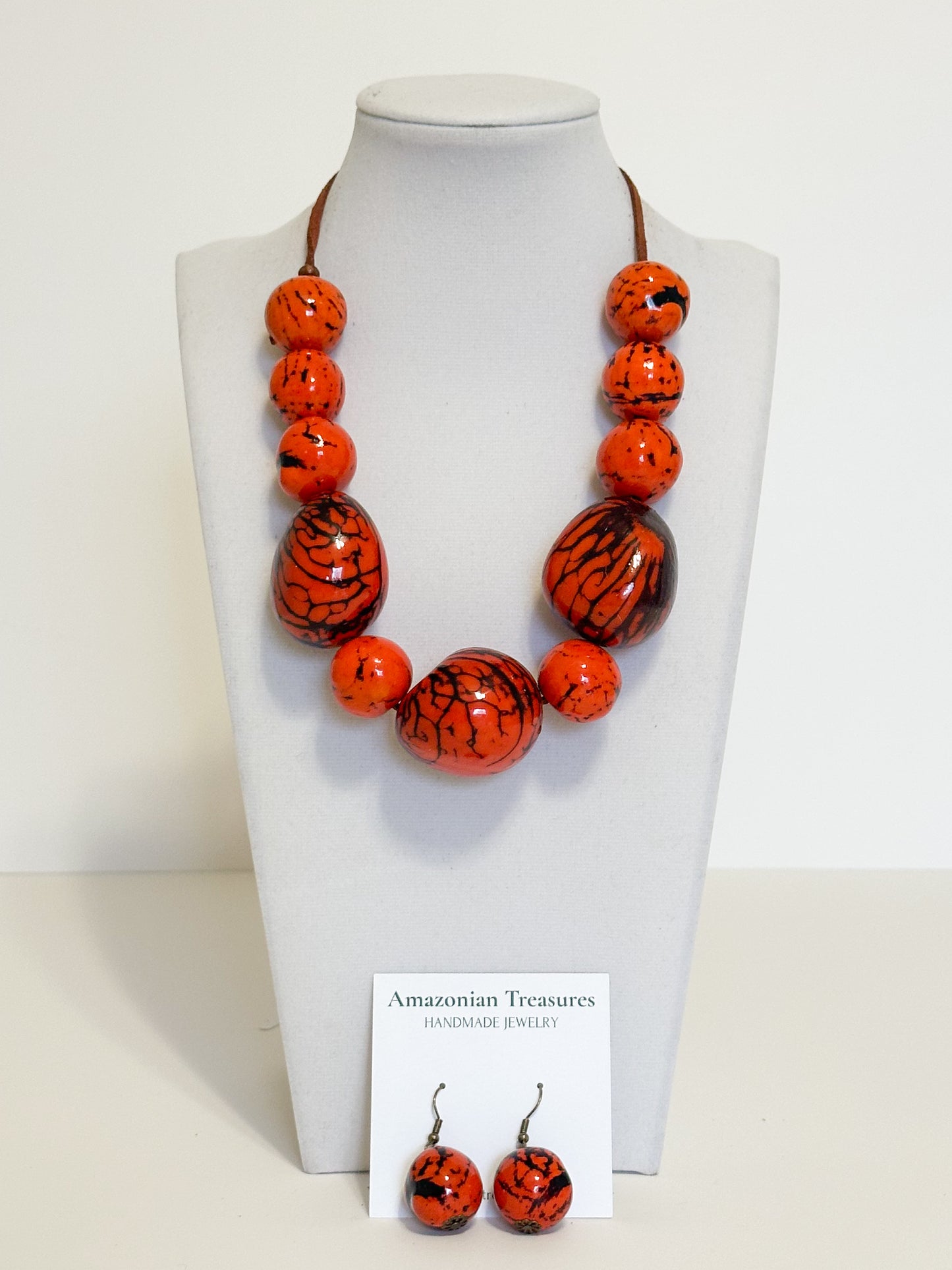 Orange dyed jarina bead necklace and earrings made by Brazilian artisan.