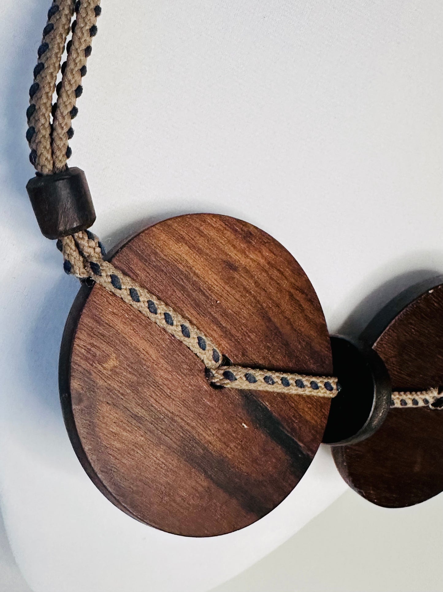 Round wood pendant detail on artisan necklace
