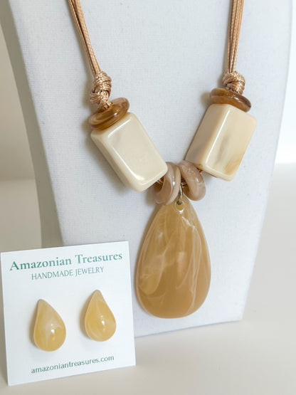 Teardrop-shaped resin pendant on cotton cord necklace.