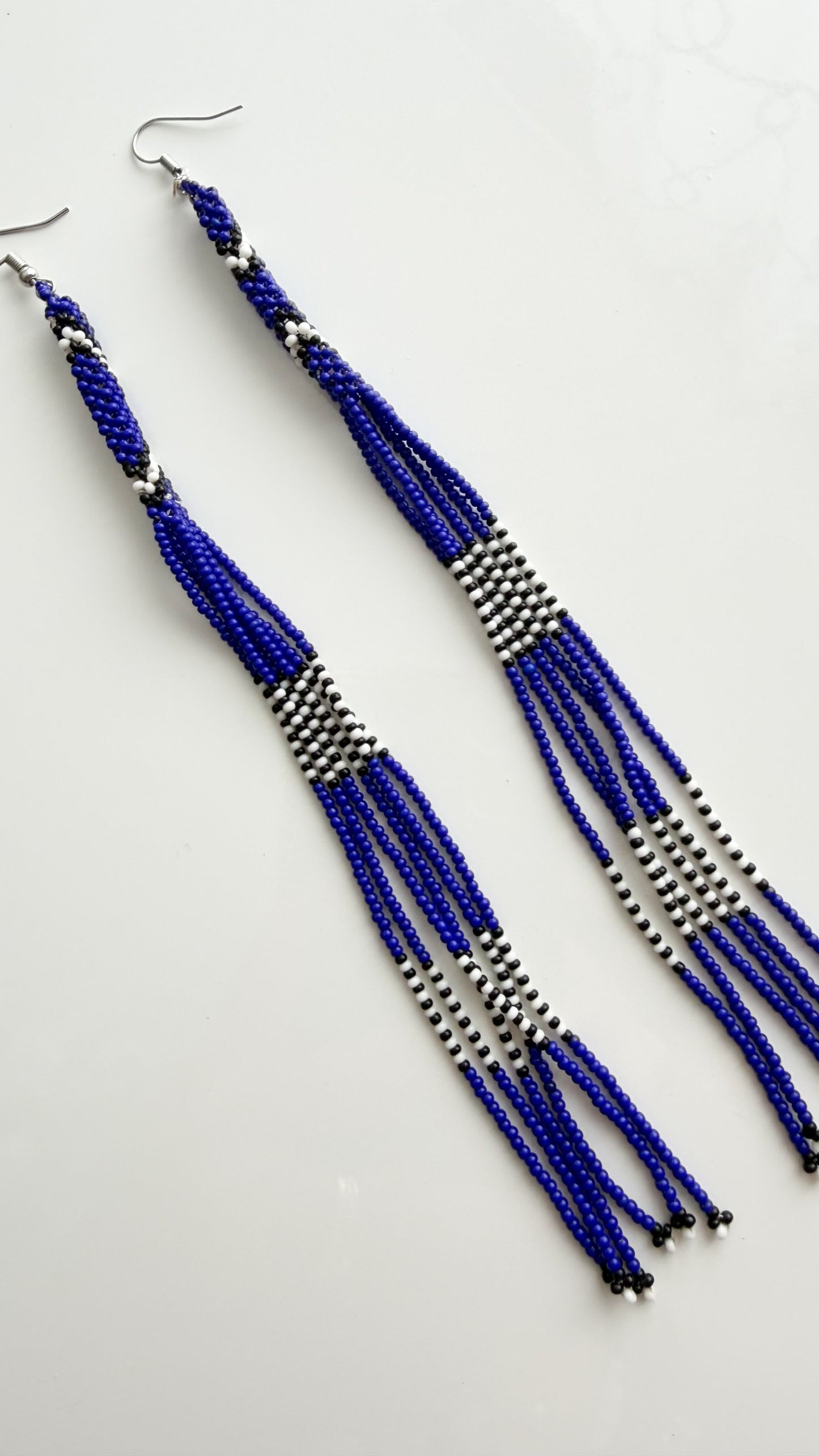 Close-up of blue, white, and black recycled glass beadwork on 6.6 inch earrings