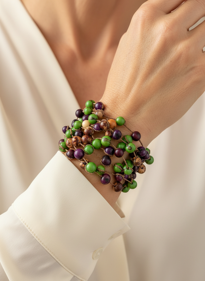 Amazonian Treasures multistrand bracelet made of natural green, purple, and brown Açaí seeds worn on a woman's wrist.
