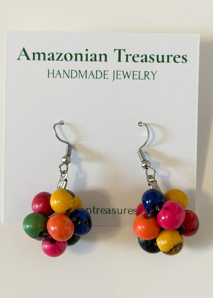 Amazonian Treasures handcrafted earrings featuring clustered, vibrant tinted Açaí seeds in red, yellow, blue, and green.
