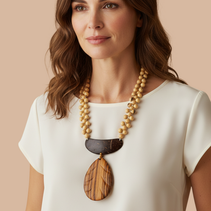 Amazonian Treasures necklace featuring acai seeds, cuia gourd, and a carved muiracatiara wood pendant on a model.