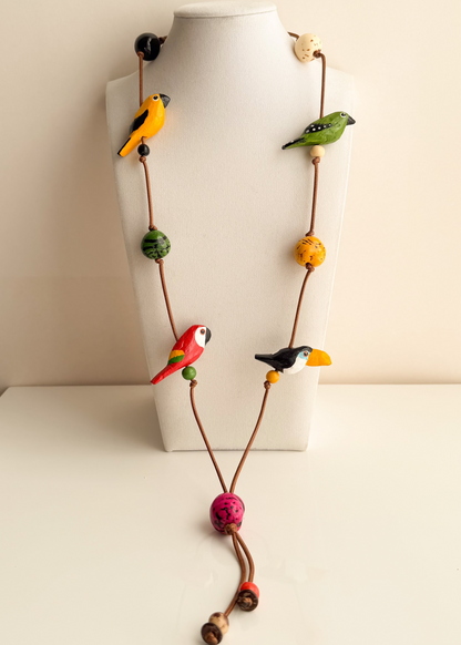 Amazonian Treasures Amazon Birds necklace featuring hand-tinted Buriti and Paxiúba wood bird charms on an earthy cord.