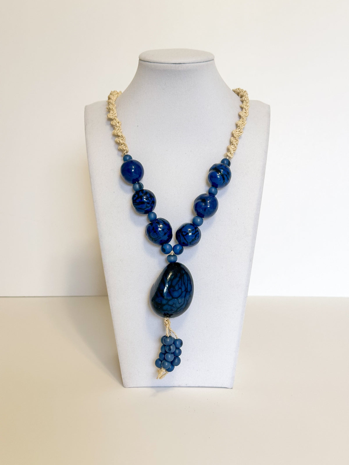 Amazonian Treasures statement necklace featuring blue polished açaí seeds and jarina on a woven tucum fiber cord.
