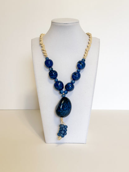 Amazonian Treasures statement necklace featuring blue polished açaí seeds and jarina on a woven tucum fiber cord.
