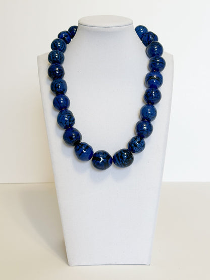 Amazonian Treasures handmade necklace featuring vibrant blue dyed paxiúba seeds with natural textures on a display bust