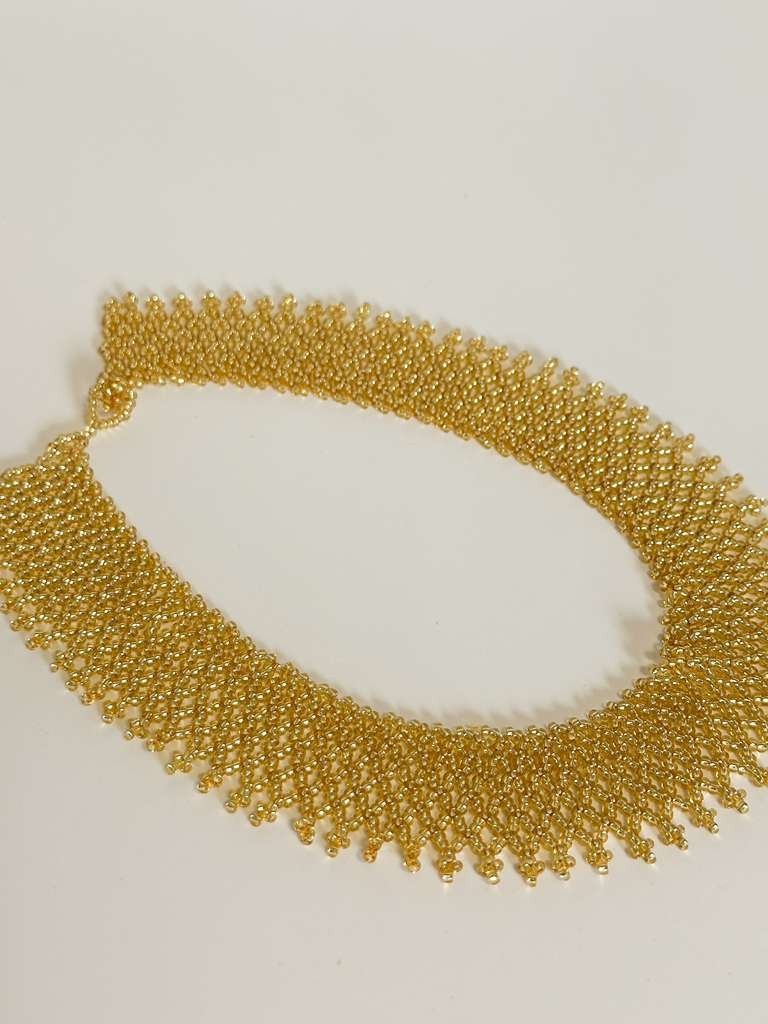 Amazonian Treasures Borari Indigenous handcrafted gold glass bead collar necklace with delicate net-like fringe.