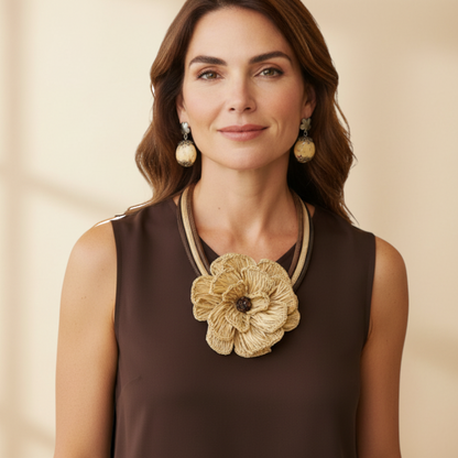 Amazonian Treasures handcrafted Buriti fiber flower necklace and Paxiúba seed earrings worn by a woman in a brown top.