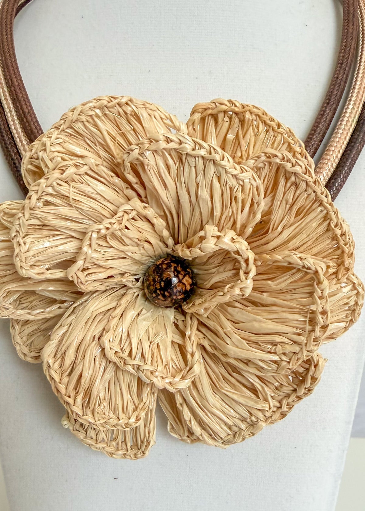 Amazonian Treasures handcrafted Buriti fiber flower statement necklace with a central Paxiúba seed on rope cords.
