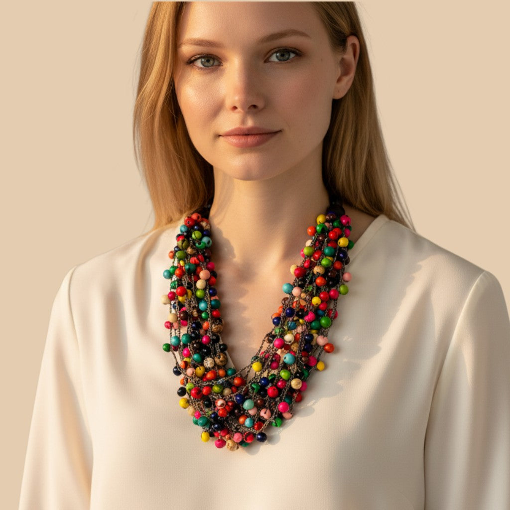 Amazonian Treasures handmade crochet necklace featuring vibrant multi-colored Açaí and Jatobá seeds on a woman