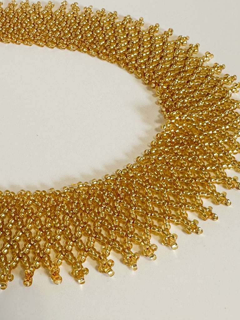 Amazonian Treasures gold glass bead collar necklace with intricate handwoven net-like Indigenous Borari beadwork.