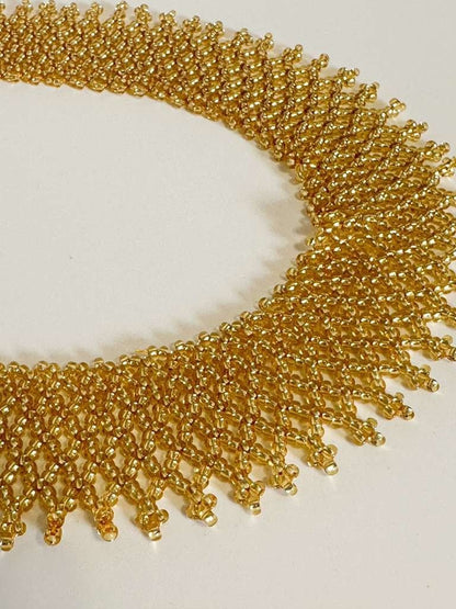 Amazonian Treasures gold glass bead collar necklace with intricate handwoven net-like Indigenous Borari beadwork.