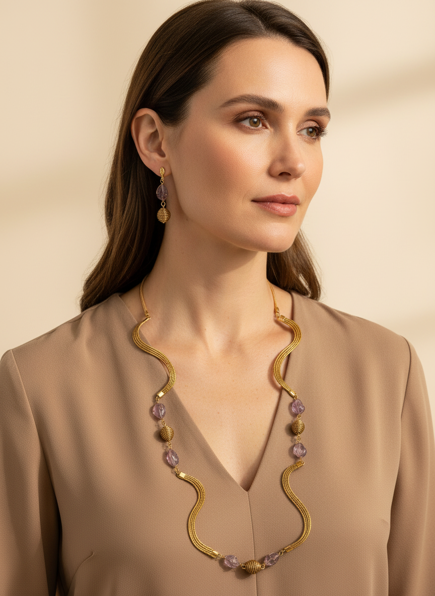 Amazonian Treasures golden grass necklace and amethyst earrings set worn by a woman in a beige blouse.