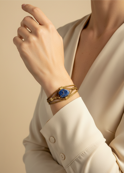 Amazonian Treasures handwoven capim dourado golden grass bracelet with a blue stone accent worn on a woman's wrist.