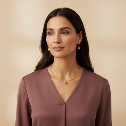 Model wearing Amazonian Treasures handwoven golden grass round choker and matching earrings against a neutral background