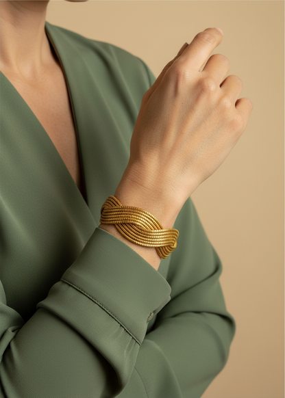 Amazonian Treasures handwoven golden grass statement cuff bracelet worn on a model in a green blouse
