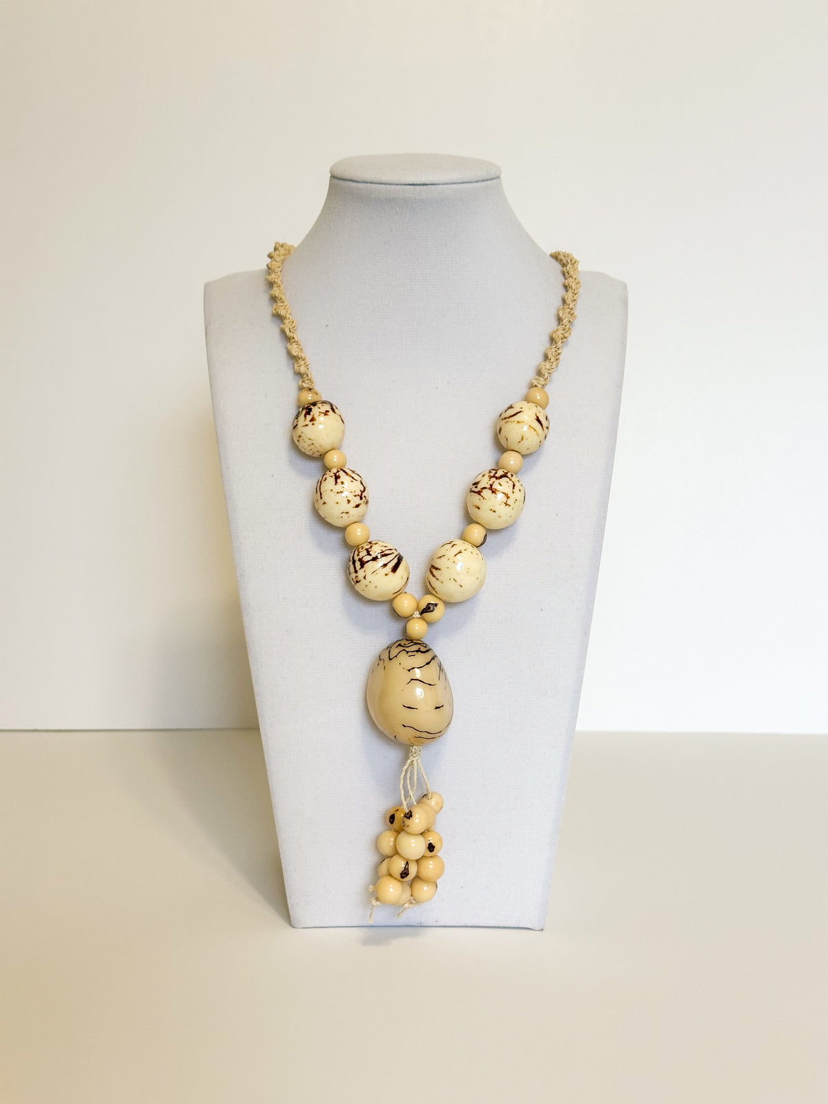 Amazonian Treasures statement necklace featuring smooth jarina seeds and tucum fiber on a white display bust.
