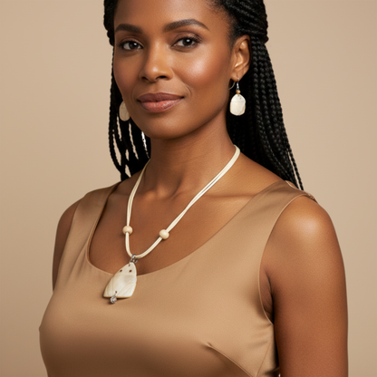 Amazonian Treasures Moonlit Muiraquitã jewelry set featuring carved mother of pearl necklace and earrings on a model.
