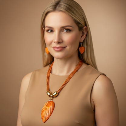 Amazonian Treasures leaf necklace and earring set in orange mother of pearl worn by a blonde woman in a tan dress.
