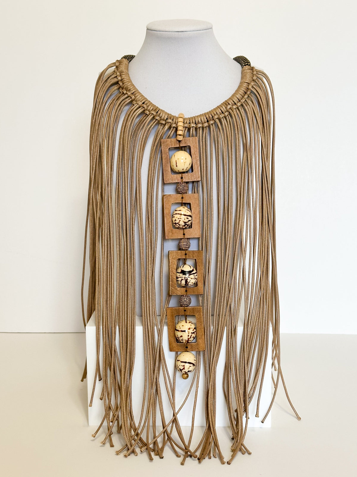 Amazonian Treasures handmade necklace with paxiúba seeds, natural wood geometric accents, and cascading cotton strands.