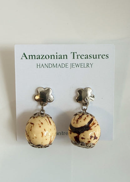 Amazonian Treasures handcrafted Paxiúba seed drop earrings with silver flower studs on a white display card