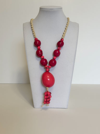 Amazonian Treasures statement necklace featuring pink acai seeds, smooth jarina, and woven tucum fiber on a mannequin.
