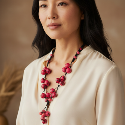 Amazonian Treasures pink Açaí and Paxiuba seed necklace worn by a woman in a cream blouse