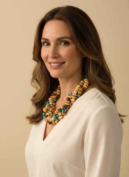 Amazonian Treasures necklace made of reclaimed wood and turquoise acai seeds worn by a woman in a white blouse.