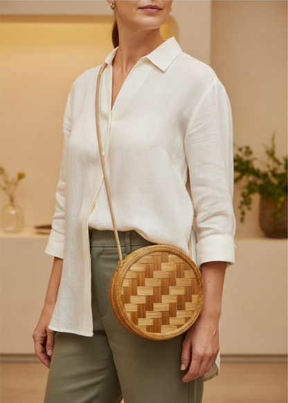 Amazonian Treasures round crossbody bag handwoven from golden capim dourado grass with a rope strap on a model