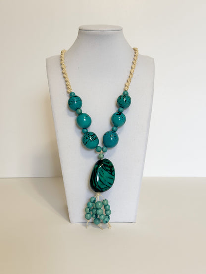 Amazonian Treasures statement necklace featuring turquoise açaí seeds and jarina on a woven tucum fiber cord.