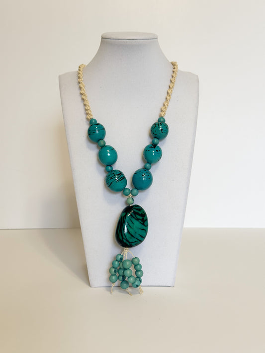 Amazonian Treasures statement necklace featuring turquoise açaí seeds and jarina on a woven tucum fiber cord.